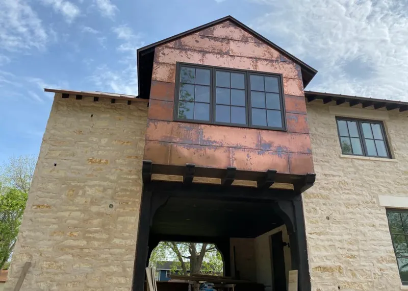 Copper metal panel facade on a stone building for Roof Repair in Woodlake