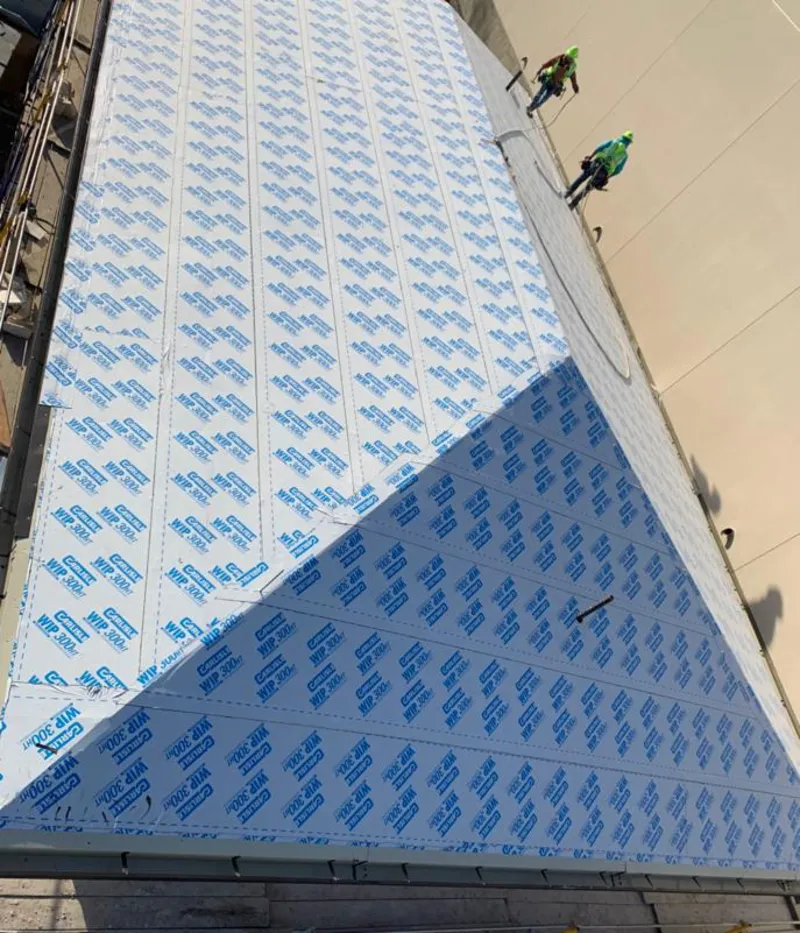 Professional roofers installing underlayment on a metal roof in Woodlake